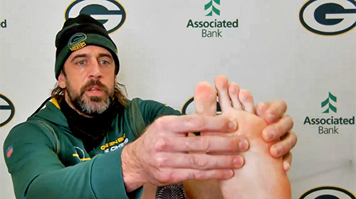 Green Bay Packers quarterback Aaron Rodgers shows his broken toe during a video news conference Nov. 24, 2021, to refute rumors he was suffering from COVID toe.